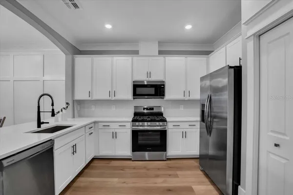 a white kitchen with stainless steel appliances