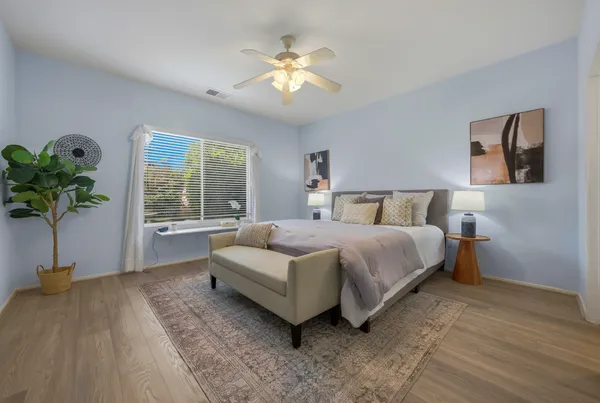 a bedroom with a large bed and a chandelier fan