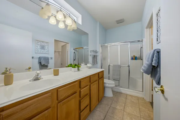 a bathroom with a granite countertop sink a toilet and a mirror