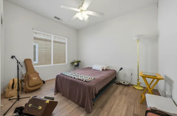 a bedroom with a bed and wooden floor