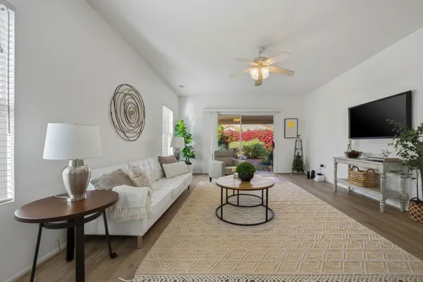 a living room with furniture a flat screen tv and a wall clock