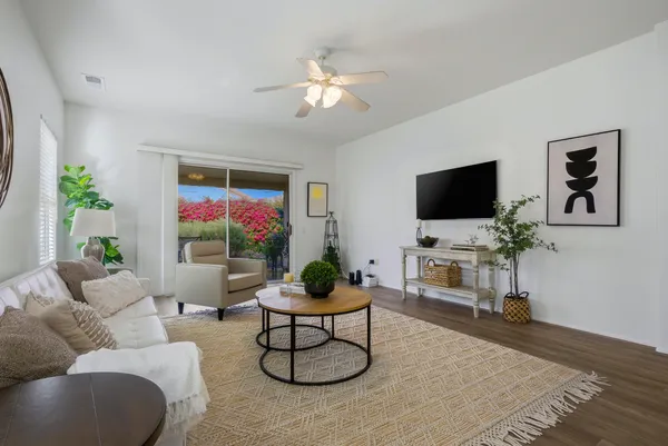 a living room with furniture a flat screen tv and a potted plant
