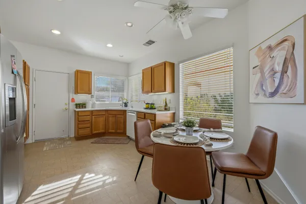 a kitchen with a dining table chairs stainless steel appliances and cabinets