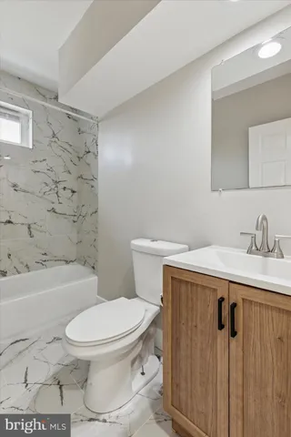 a white toilet sitting next to a bathroom sink and a shower