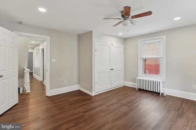a view of an empty room with wooden floor