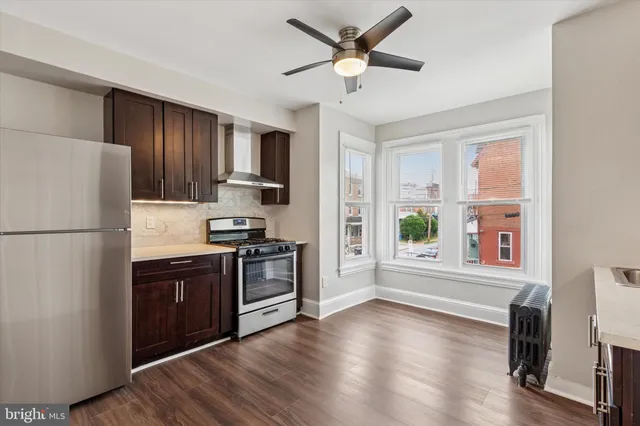 a kitchen with a refrigerator stove and wooden floor