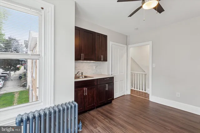 a large bedroom with a bed and wooden floor
