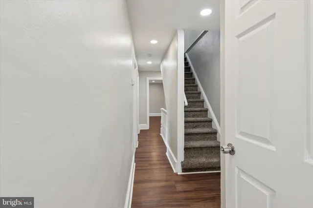 a view of a hallway with wooden floor and entryway