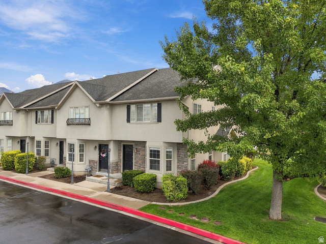 1041 South 1850th Street West Springville, UT 84663 - Photo 4 of 35 Multi-level townhome exterior with stone accents, black shutters, and mature landscaping