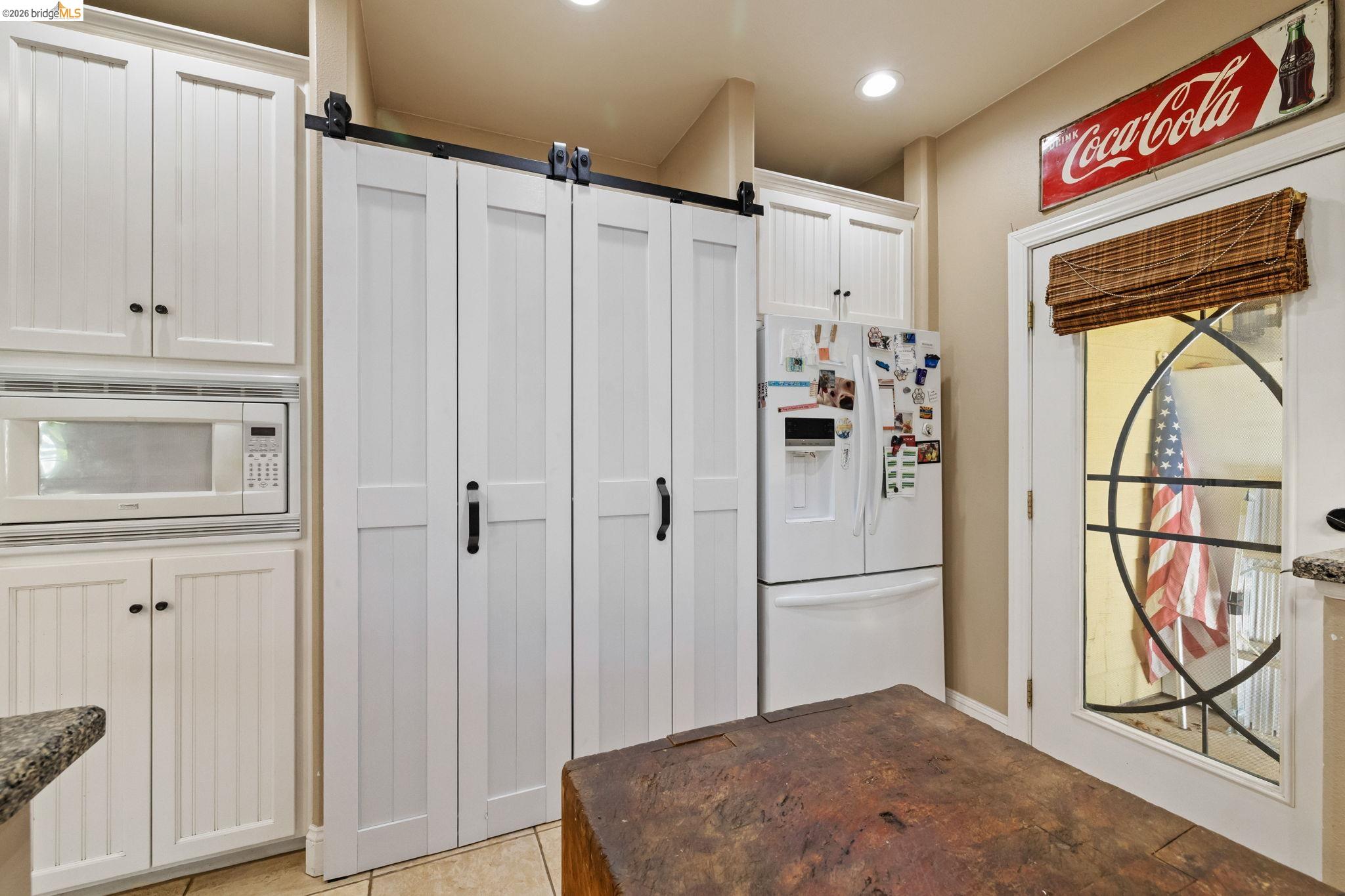 10177 Pulpit Rock Road Jamestown, CA 95327 - Photo 13 of 60 Kitchen featuring white appliances, white cabinets, a barn door, and recessed lighting