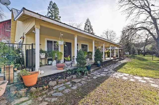 a view of a house with backyard and sitting area