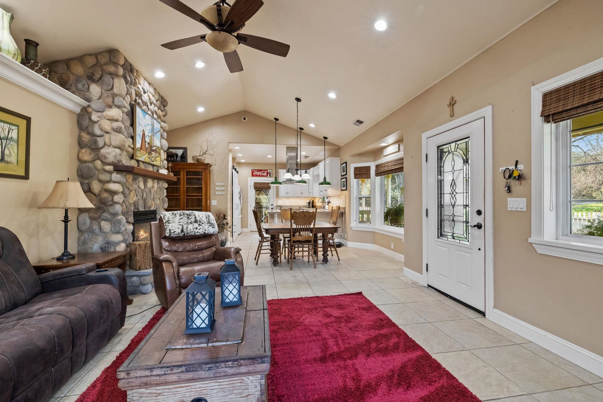 10177 Pulpit Rock Road Jamestown, CA 95327 - Photo 7 of 60 Living room with lofted ceiling, ceiling fan, a fireplace, and light tile patterned flooring