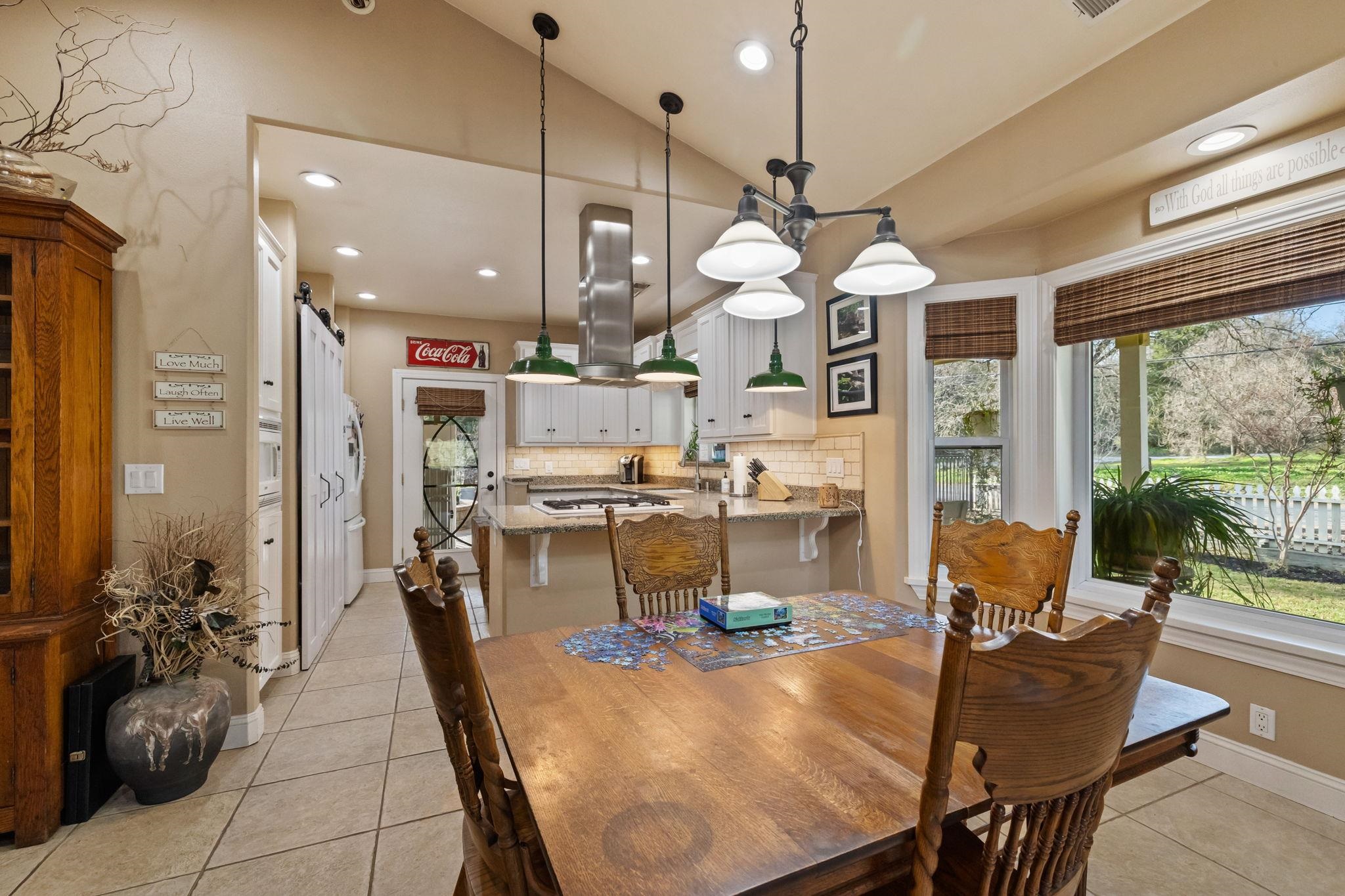 10177 Pulpit Rock Road Jamestown, CA 95327 - Photo 8 of 60 Dining area with lofted ceiling, a barn door, light tile patterned floors, recessed lighting, and healthy amount of natural light