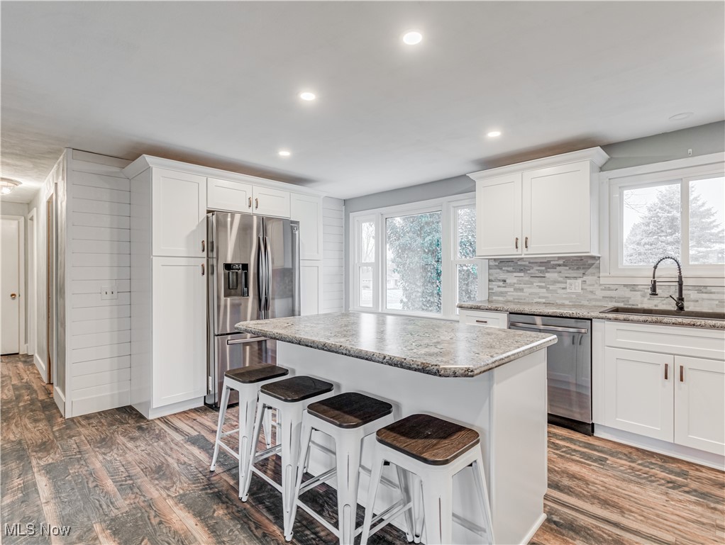 6385 Firestone Road Northeast Canton, OH 44721 - Photo 8 of 22 Kitchen featuring white cabinets, stainless steel appliances, and a healthy amount of sunlight