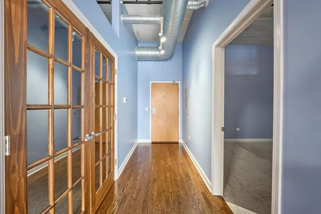 a view of a hallway with wooden floor and staircase