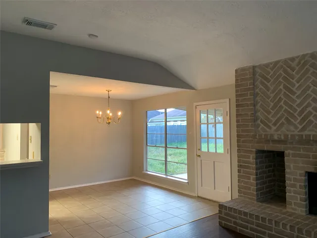 a view of an empty room with a fireplace and a window