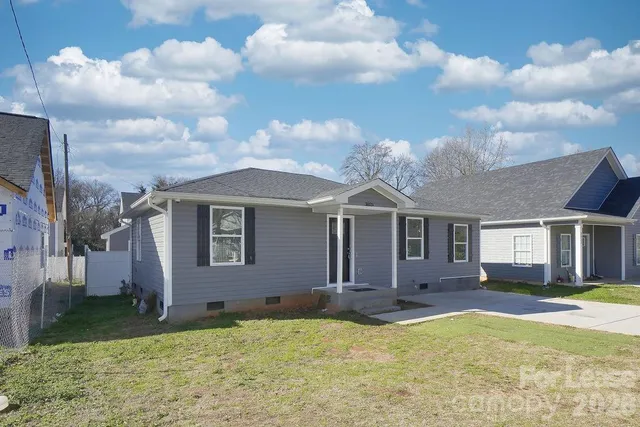 a front view of a house with yard and tress