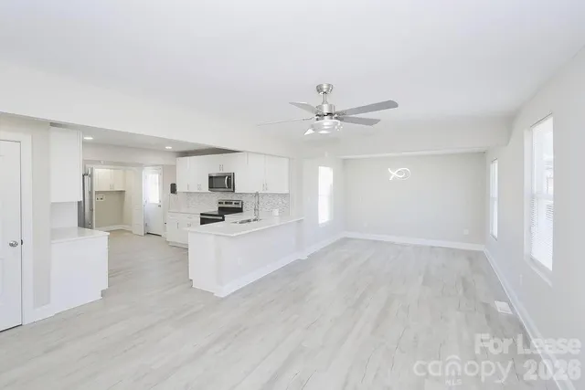 a view of kitchen with livingroom and wooden floor