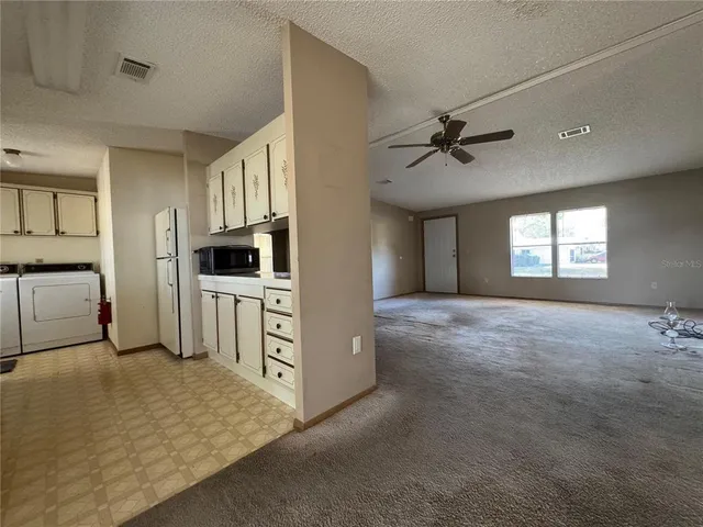 a view of a kitchen with sink cabinet and windows