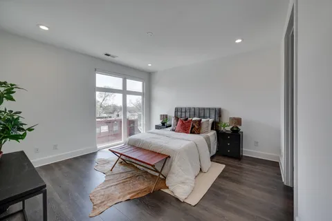 a bedroom with a bed and a potted plant
