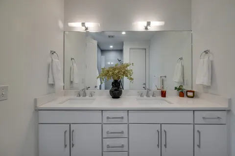 a bathroom with a sink double vanity and a mirror