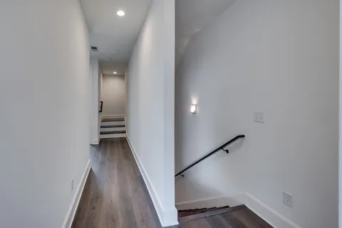 a view of a hallway with wooden floor and staircase
