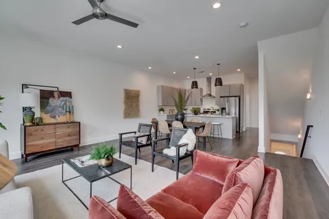 a living room with furniture and a view of kitchen