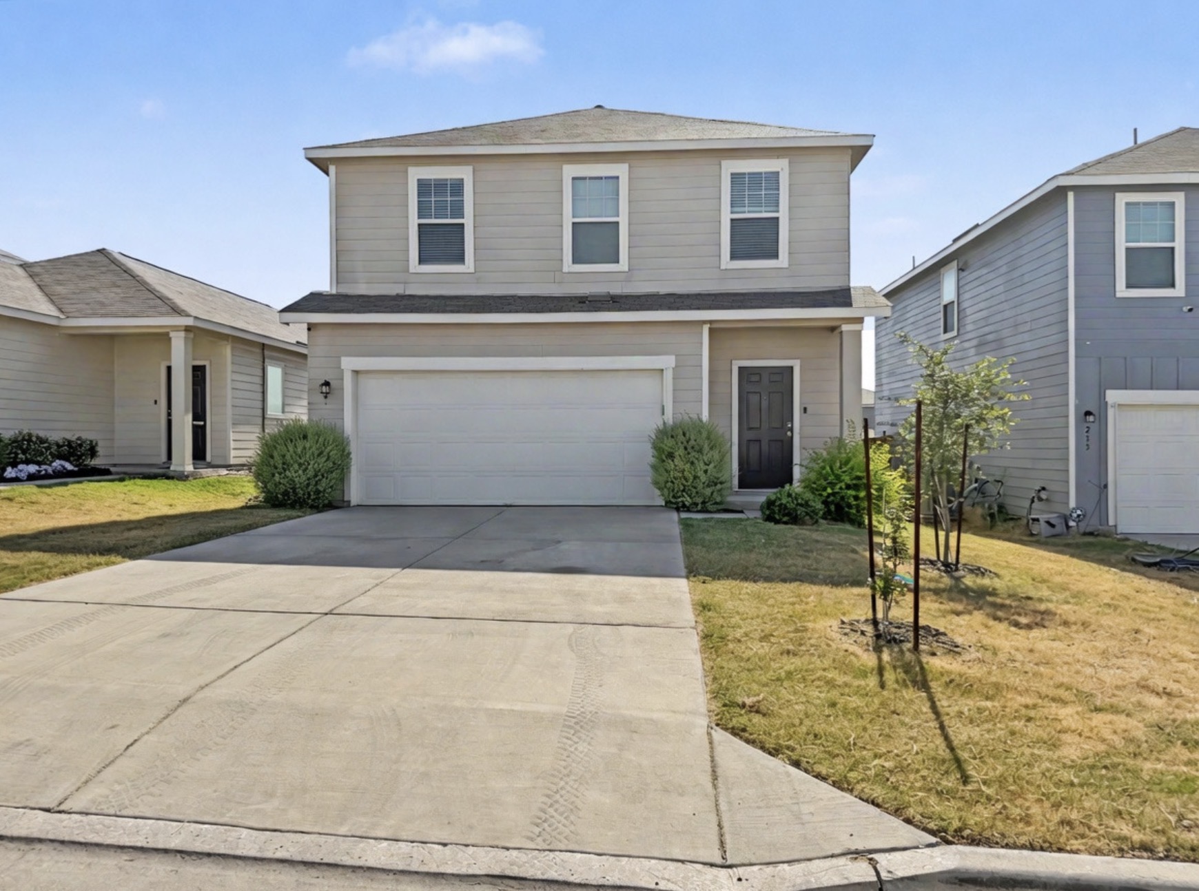 A classic two-story exterior features a neutral color scheme and an attached two-car garage.