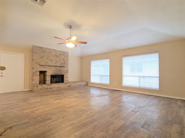 a view of an empty room with a fireplace and a window