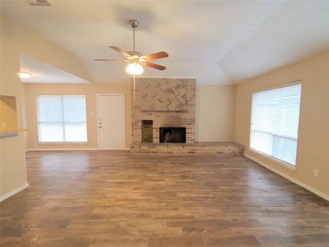 an empty room with windows and fireplace