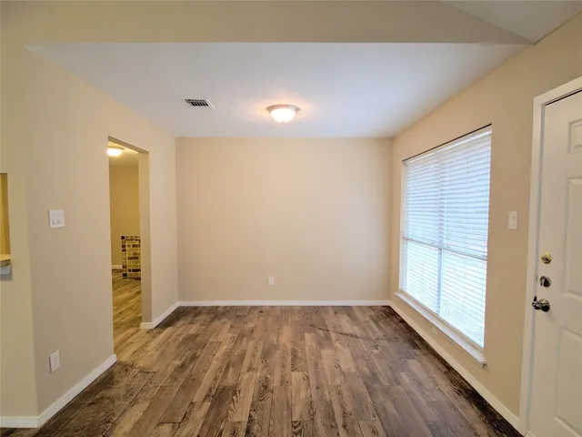 wooden floor in an empty room with a window