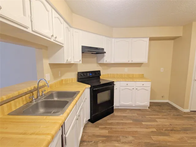 a kitchen with a sink stove and cabinets