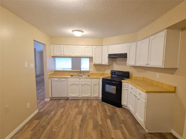 a kitchen with granite countertop white cabinets and white appliances