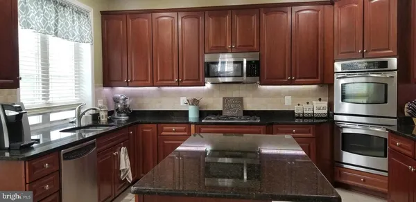 a kitchen with wooden cabinets and stainless steel appliances