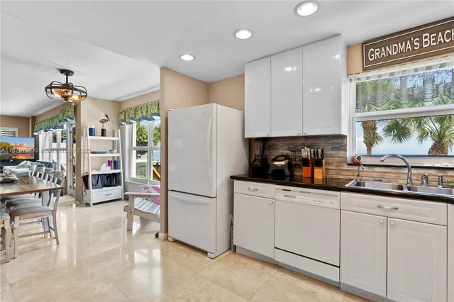 a kitchen with granite countertop a sink a window and cabinets