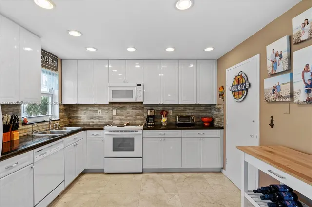 a kitchen with stainless steel appliances granite countertop a refrigerator and a stove