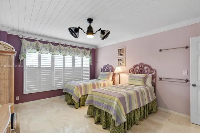 a bedroom with two beds and a chandelier