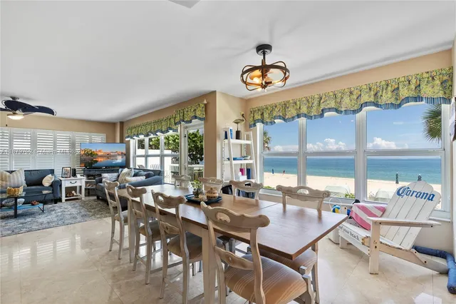 a room with lots of white furniture and a large window