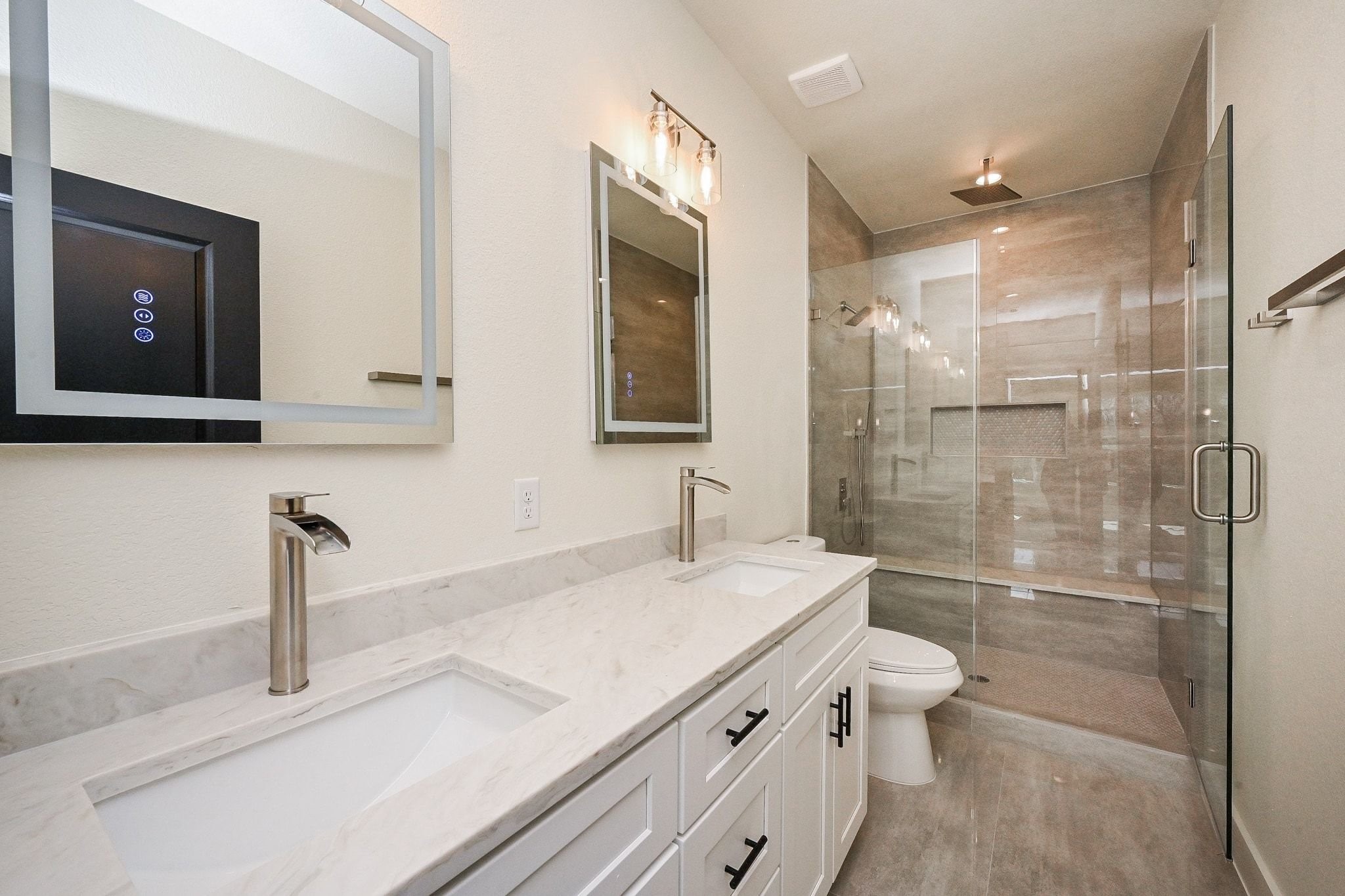 3839 Noah Street, Unit B Houston, TX 77021 - Photo 12 of 19 This modern bathroom features a sleek double vanity with marble countertops, stylish square sinks, and contemporary fixtures. It includes a spacious glass-enclosed shower with elegant tile work, offering a luxurious feel.