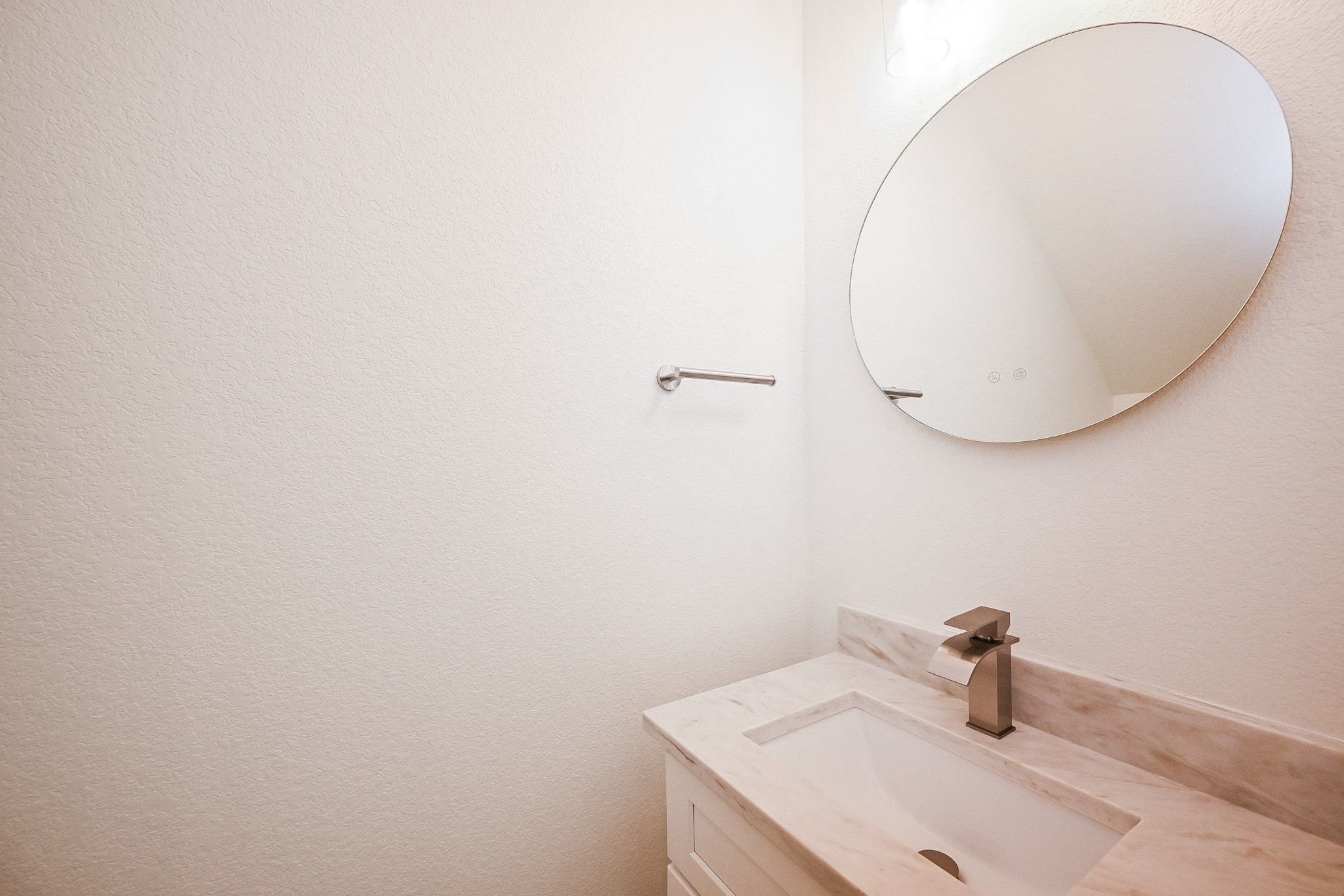 3839 Noah Street, Unit B Houston, TX 77021 - Photo 15 of 19 This bathroom features a minimalist design with a round mirror, modern faucet, and a sleek marble countertop.