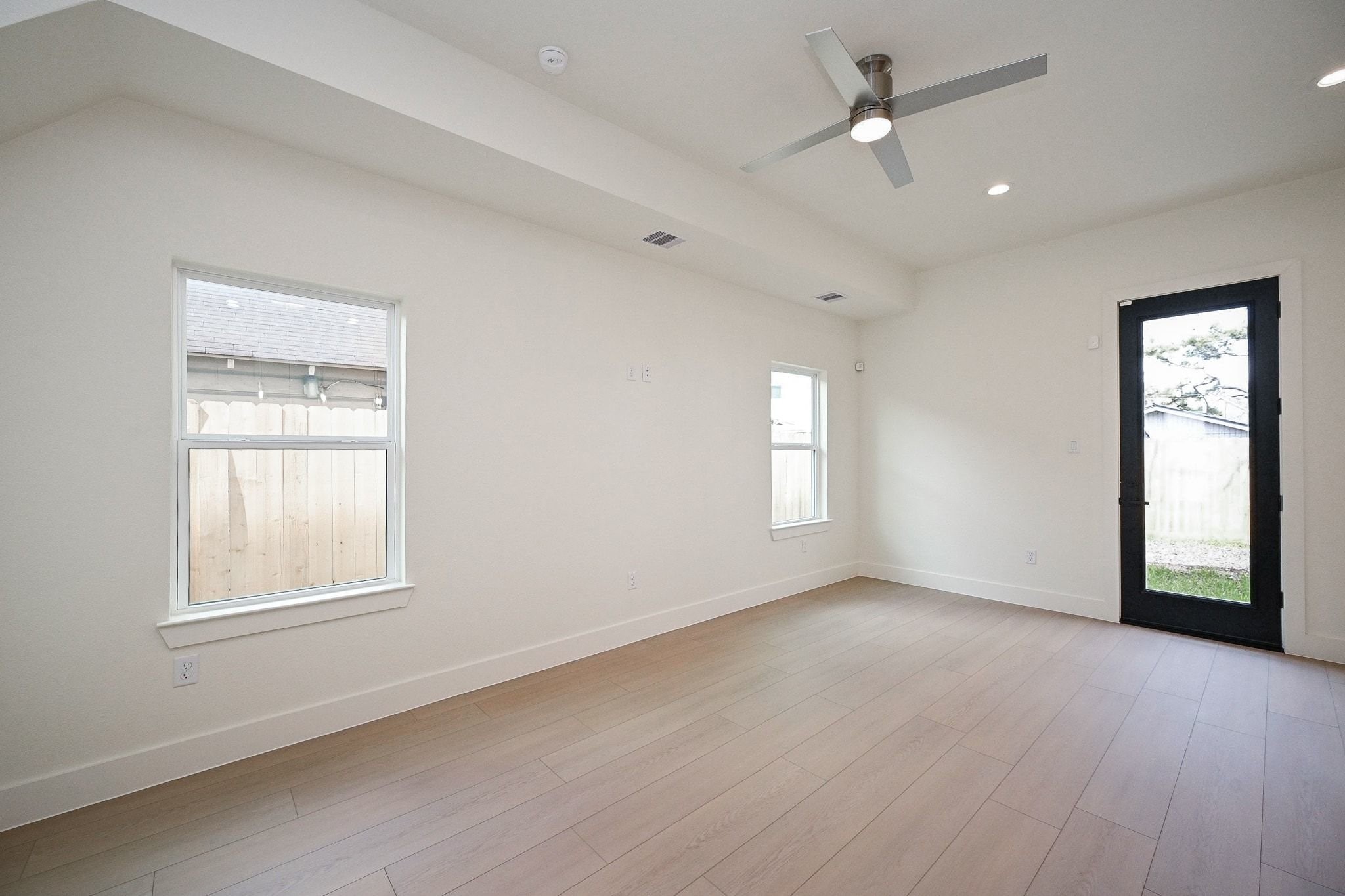 3839 Noah Street, Unit B Houston, TX 77021 - Photo 8 of 19 This bright room features light wood flooring, a ceiling fan, and ample natural light from two windows and a glass door leading outside.