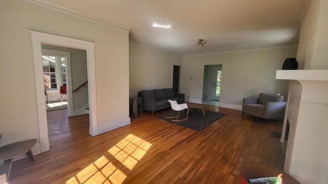 a living room with furniture and a wooden floor