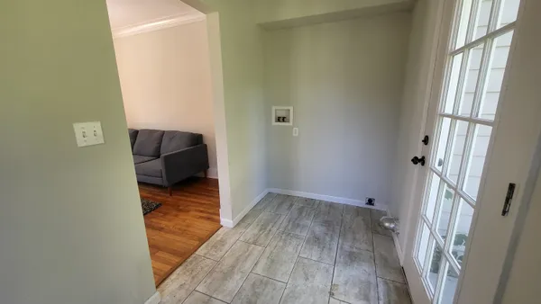 a view of a hallway with wooden floor and a cabinet