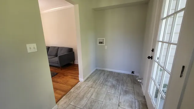 a view of a hallway with wooden floor and a cabinet