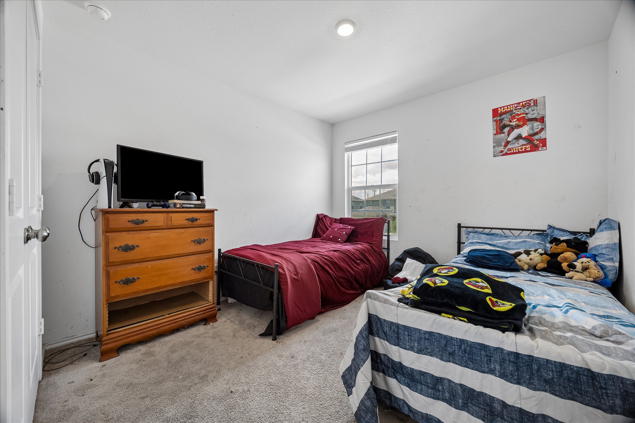 217 Canley Loop Hutto, TX 78634 - Photo 26 of 36 A window fills this restful bedroom with natural light, complementing the comfortable carpeted flooring.