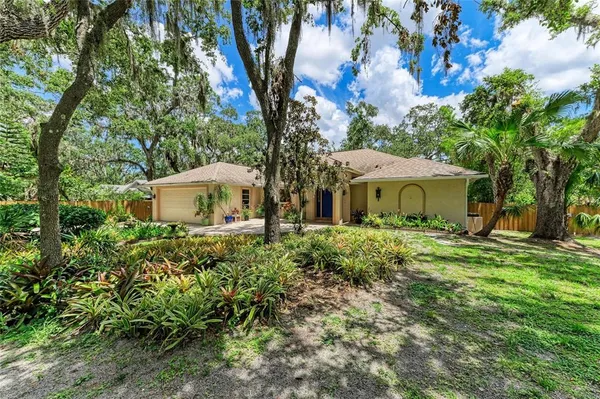 a front view of a house with a yard and tree