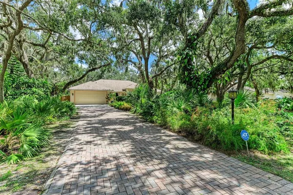 a view of a house with a yard and a tree