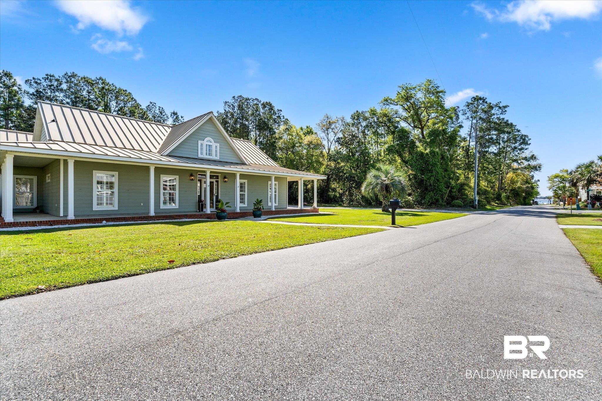 4947 Look Rook Road Orange Beach, AL 36561 - Photo 23 of 24 View of front of house with a standing seam roof, a front yard, covered porch, and metal roof