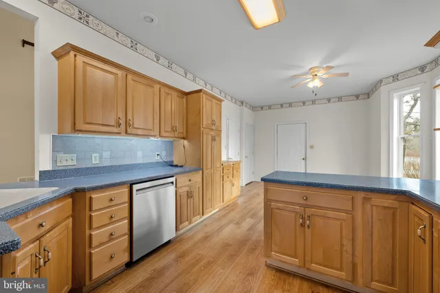 a kitchen with stainless steel appliances granite countertop a stove a sink dishwasher and cabinets with wooden floor