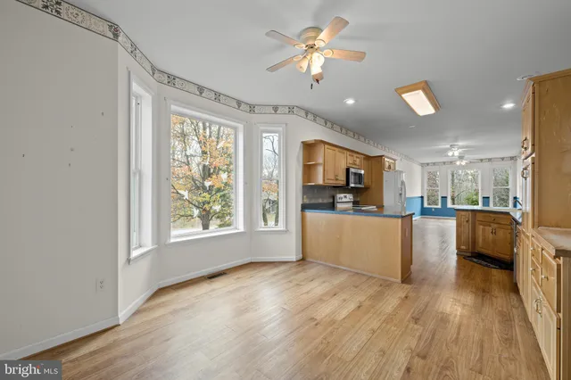 a view of a kitchen with furniture a window and wooden floor